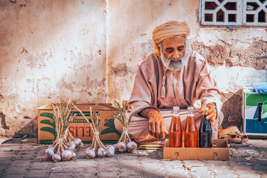 man sitting on the ground by his market