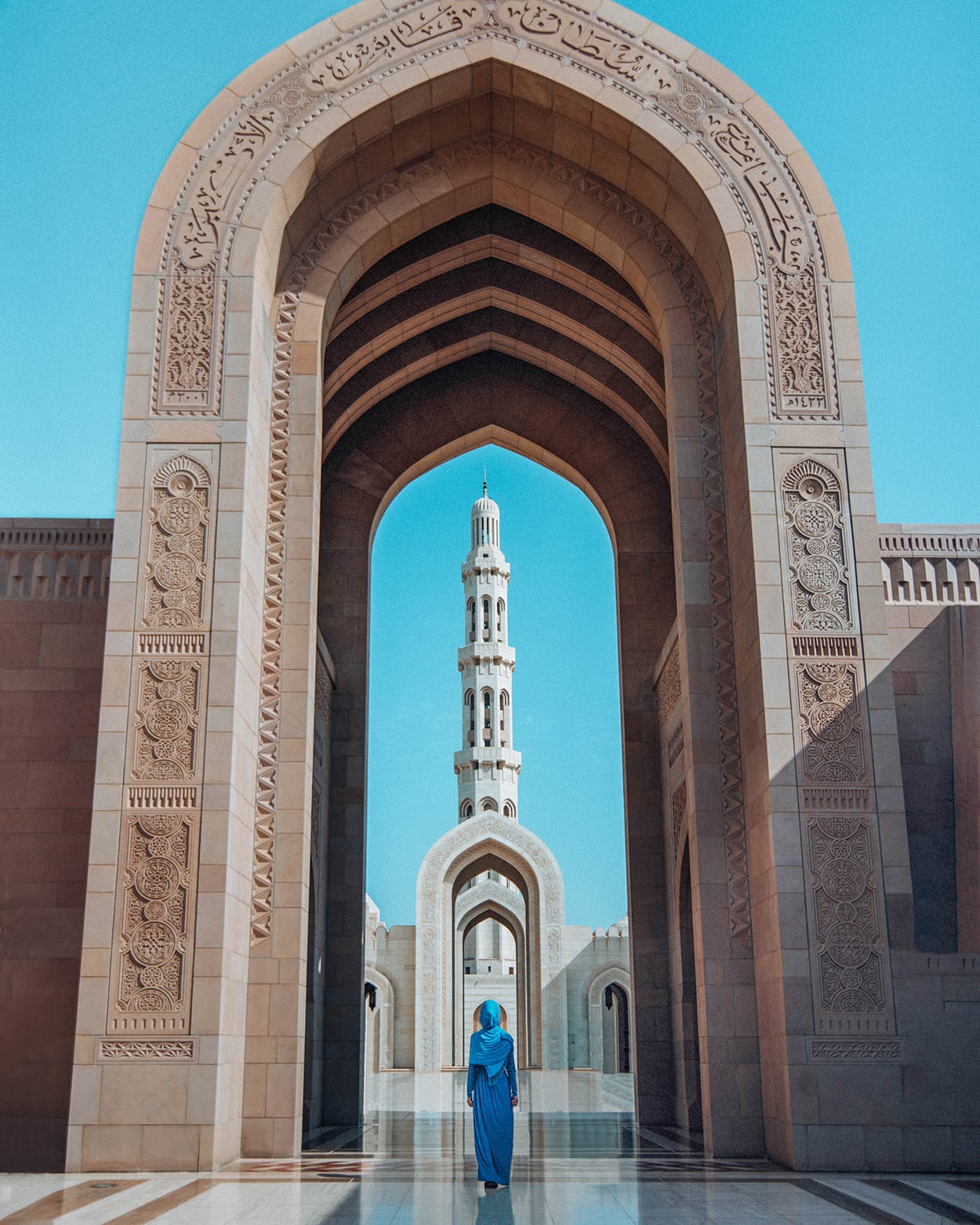 girl standing in sultan qaboos grand mosque in muscat oman
