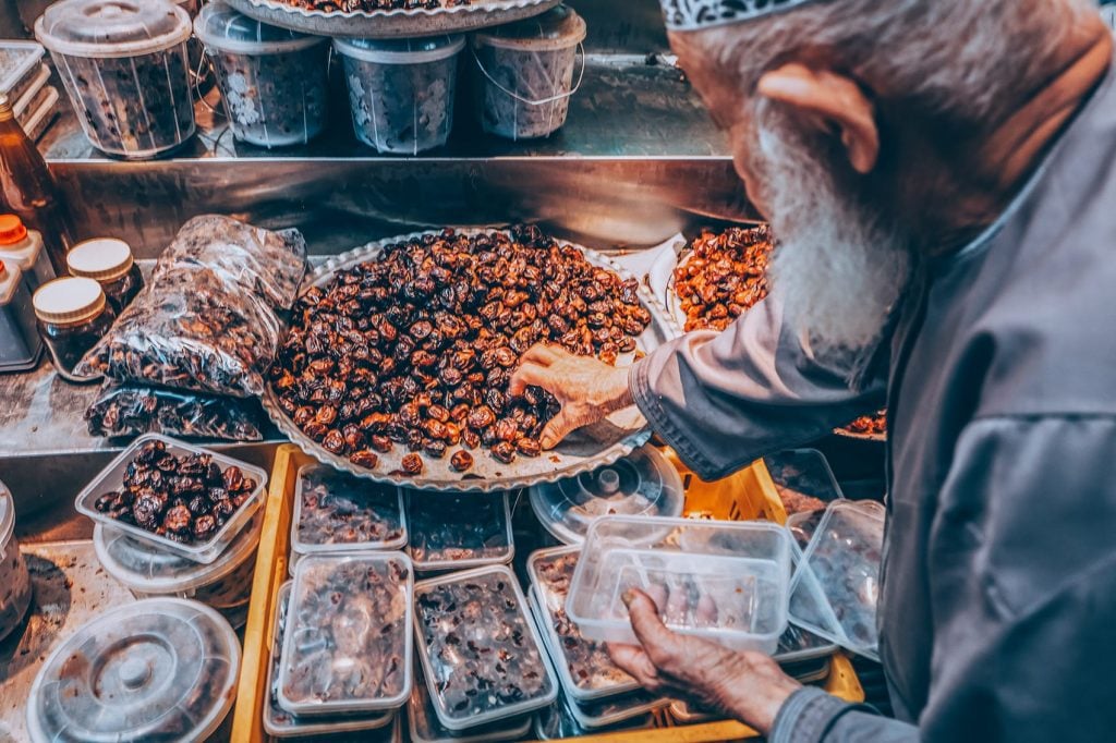 man picking up dates at a market