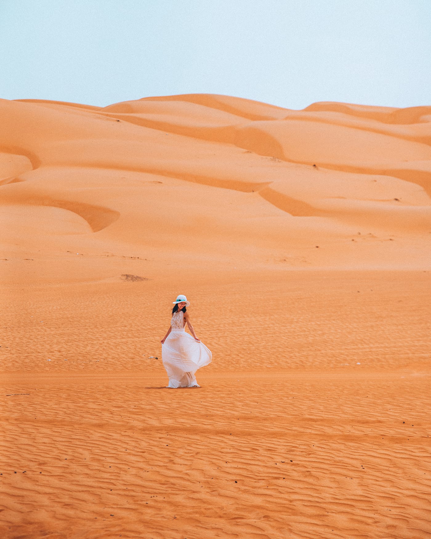 girl in a white dress on wahiba sands desert