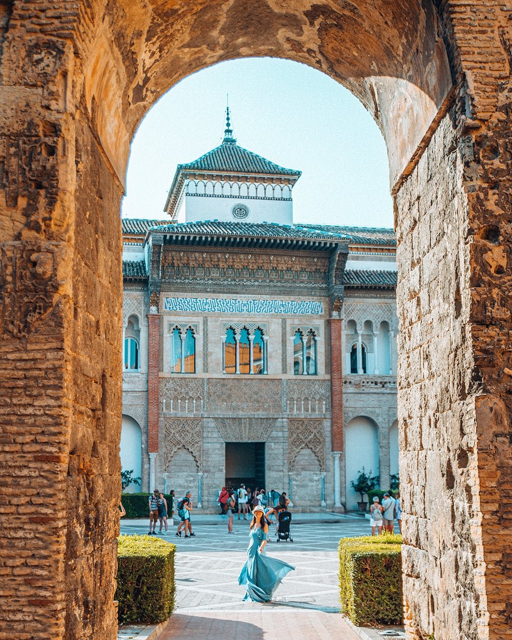 girl standing amongst the moorish architecture of royal alcazar of seville spain