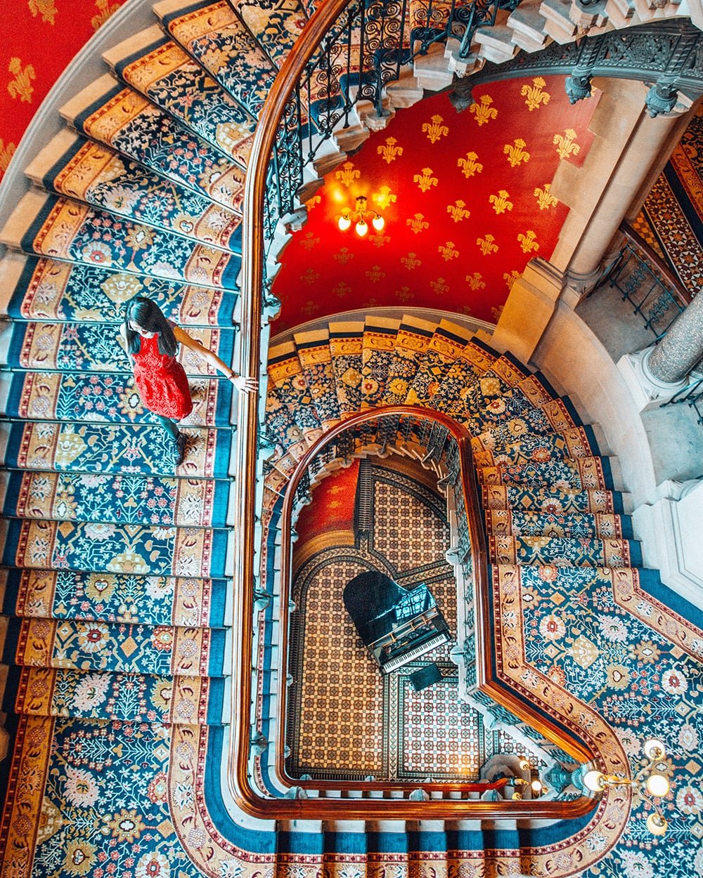 a girl walking down the stairs of st pancras renaissance hotel in london