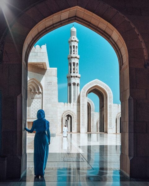 girl standing in front of sultan qaboos grand mosque in muscat oman