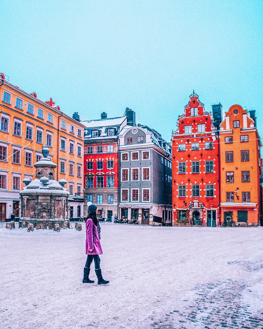 a girl walking in the colorful old town of stockholm sweden