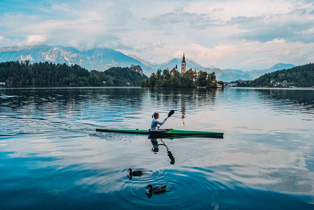 a woman kayaking in lake bled in slovenia