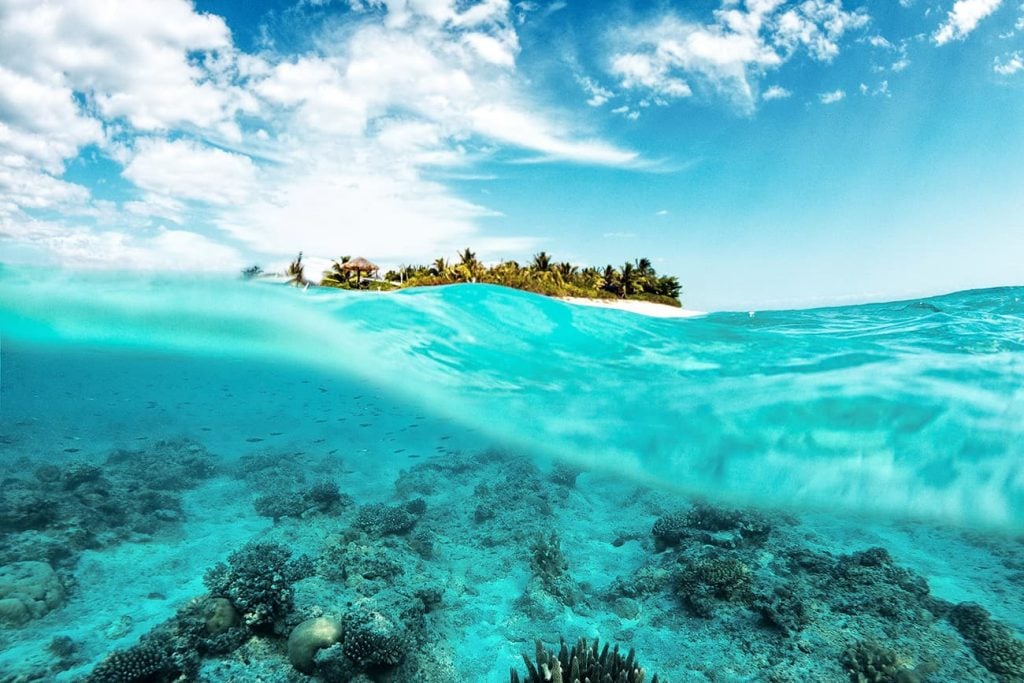 Clear Water in an Ocean With an Island in the Distance