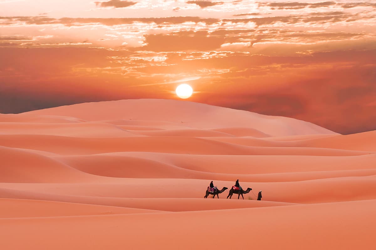 The Sun Setting Over Desert Dunes