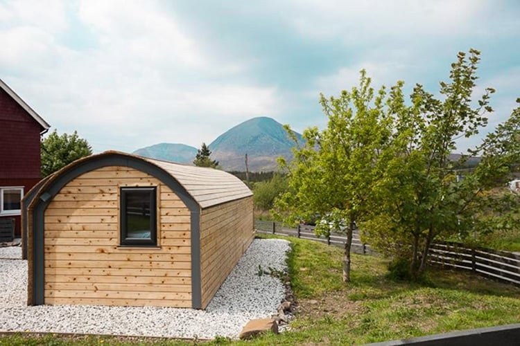a small wooden building with a mountain in the background